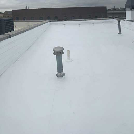 Top view of a large commercial building with a flat, white roof