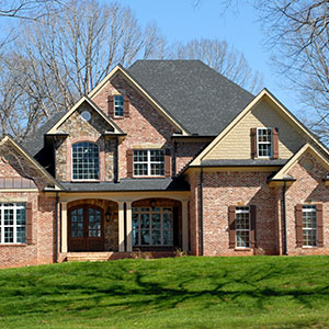Front view of a mid-class home with gray shingles on its roof
